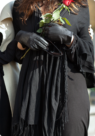 woman holding a rose while attending a funeral